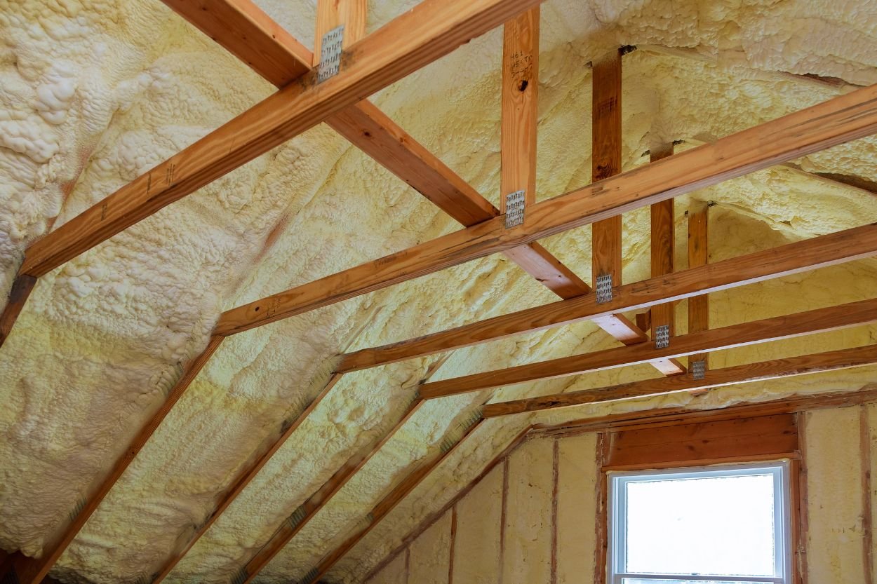 Insulated attic featuring wood framing, highlighting an area designated for mold removal services in Austin, TX.